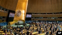 FILE - Delegations stand for a moment of silence during an emergency session of the U.N. General Assembly, Feb. 28, 2022, at United Nations Headquarters in New York.