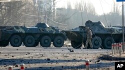 ទាហាន​ម្នាក់​ដើរ​កាត់​រថក្រោះ​អ៊ុយក្រែន​នៅ​លើ​ផ្លូវមួយ​ក្នុង​ទីក្រុង​កៀវ ប្រទេស​អ៊ុយក្រែន​នៅ​ថ្ងៃទី២៦ ខែកុម្ភៈ ឆ្នាំ២០២២។ (AP)