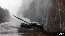 在卢甘斯克地区的路边，被乌军摧毁的一辆俄军坦克冒着浓烟。(2022年2月26日)