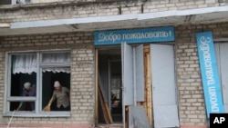 Two women sweep up broken glass at a school building in Horlivka, following Ukrainian shelling in the territory controlled by pro-Russian militants, eastern Ukraine, Feb. 25, 2022.