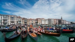 Gondolas are lined up during the Vogada della Rinascita (Rowing of Rebirth) regatta, along Venice canals, Italy, as European Union is close to finalizing a list of countries whose citizens will be allowed back into Europe once restrictions are lifted.