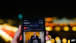 The app of Facebook showing U.S. President Joe Biden speaking, is viewed on an smartphone in Moscow, Russia, Friday, Feb. 25, 2022. Russia announces 'partial restriction' of access to Facebook over platform's restrictions on Kremlin-backed media. (AP Photo)