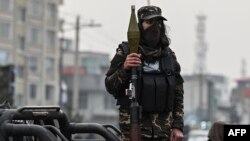 Seorang anggota pasukan Taliban berdiri memegang roket peluncur granat di sebuah kendaraan yang melaju di area Kabul, Afghanistan, pada 21 Januari 2022. (Foto: AFP/Mohd Rasfan)