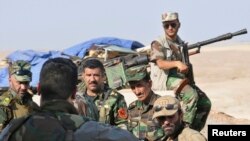 Kurdish "peshmerga" troops stand guard during an intensive security deployment on the outskirts of Sinjar, west of Mosul, Aug. 5, 2014. 