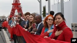 Para aktivis lingkungan menunjukkan keinginan mereka bagi tercapainya kesepakatan iklim dengan membentangkan kain warna merah di Le Bourget, hari Jumat (11/12). 