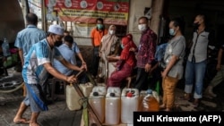 Warga antre membeli minyak goreng murah dari operasi pasar di Surabaya, Jawa Timur, 18 Februari 2022. (Foto: Juni Kriswanto/AFP)