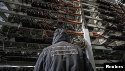 FILE - An employee works at the data center of a company providing services for cryptocurrency mining, in the city of Bratsk in Irkutsk region, Russia, March 2, 2021. 