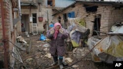 A woman is overwhelmed by emotion in the backyard of a house damaged by a Russian airstrike, according to locals, in Gorenka, outside Kyiv, Ukraine, March 2, 2022. 