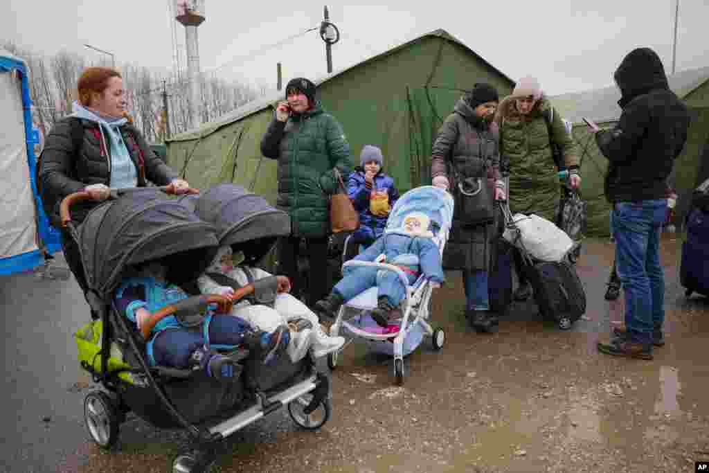Refugees fleeing war from neighboring Ukraine stand near tents after crossing the border in Palanca, Moldova, March 2, 2022.