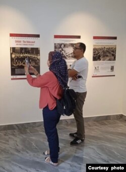 Pengunjung Museum Holocaust di Minahasa, Sulawesi Utara, tampak mengambil beberapa gambar dari poster informasi yang dipajang di dalam museum yang baru diresmikan pada Januari 2022. (Foto: Courtesy of Yaakov Baruch)