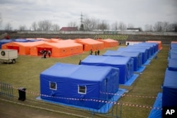 Kemah penampungan sementara untuk pengungsi Ukraina didirikan di atas lapangan sepak bola di Siret, Romania, 27 Februari 2022. (AP/Andreea Alexandru)