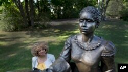 FILE - In this photo taken Aug. 25, 2016, JerriAnne Boggis stands next to a statue of Harriet Wilson in Milford, N.H. 