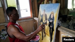 Ghanaian movie poster artist Daniel Anum Jasper, 54, works on a commissioned movie poster for a foreign client at his worksop in Accra, Ghana February 11, 2022. (REUTERS/Francis Kokoroko)