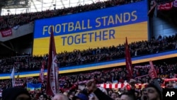 A video screen displays the Ukrainian flag, during the English League Cup final soccer match between Chelsea and Liverpool at Wembley stadium in London, Feb. 27, 2022.