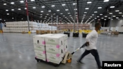 Kardus-kardus berisi vaksin Covid-19 buatan Moderna sedang disiapkan untuk dikirim di pusat distribusi McKesson, di Olive Branch, Mississippi, 20 Desember 2020. 