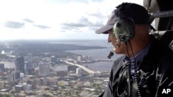 FILE - In this Sept. 12, 2017 photo, Gov. Rick Scott assesses flooding damage over Jacksonville, Fla., in the aftermath of Hurricane Irma. 