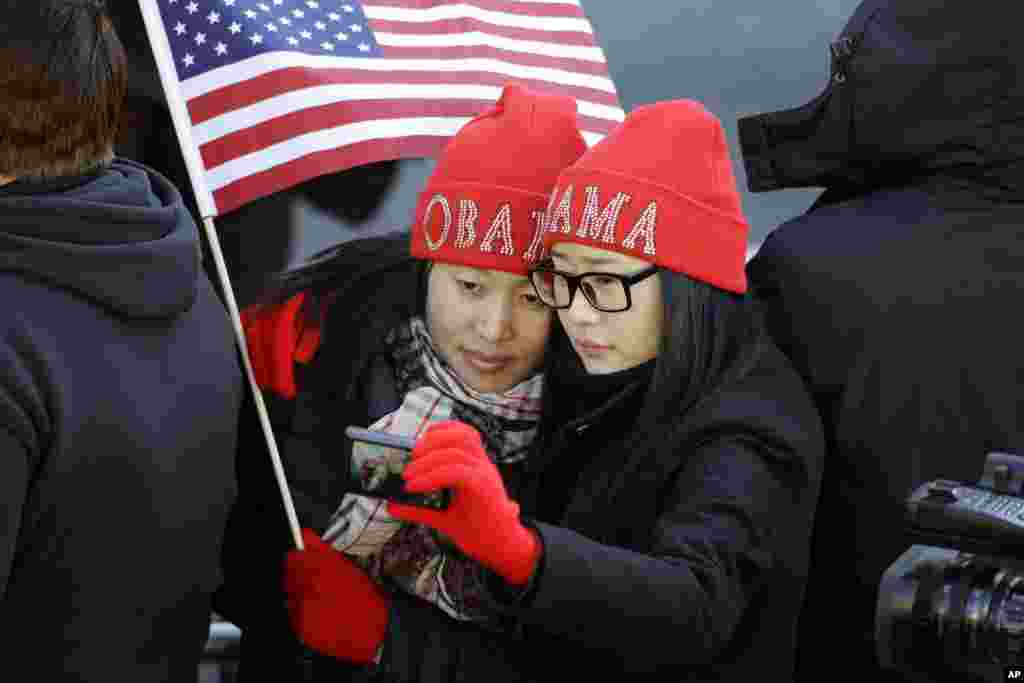 Khongorzul Battsengel (kiri) dan Ariunbolor Davaatsogt, keduanya dari Mongolia, memotret diri saat menanti Presiden Barack Obama dalam parade inaugurasi presiden ke-57 di Pennsylvania Ave. di Washington D.C. (21/1). (AP/Alex Brandon)