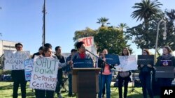 FILE - Immigrant advocates rally outside the Orange County Board of Supervisors' meeting room in Santa Ana, Calif., Tuesday, March 27, 2018, to protest a proposal to join a U.S. government lawsuit against California over the state's so-called sanctuary law. A federal judge on July 5, 2018, rejected a request by the Trump administration to block two California laws that protect immigrants in the country illegally. 