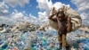 FILE - A man walks on a mountain of plastic bottles as he carries a sack of them to be sold for recycling after weighing them at the dump in the Dandora slum of Nairobi, Kenya, on Dec. 5, 2018. 