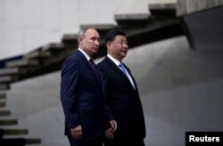 Presiden Rusia Vladimir Putin dan Presiden China Xi Jinping berjalan menuruni tangga saat mereka tiba untuk KTT BRICS di Brasilia, Brazil, 14 November 2019. (Foto: REUTERS/Ueslei Marcelino)