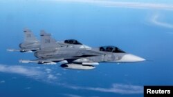 This file photo shows Sweden's Air Force "Grippen" fighters escorting a Lithuanian Air Force C-27J plane during NATO joint military exercise in Siauliai April 1, 2014. (REUTERS/Ints Kalnins)