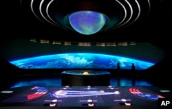 Staff members explain to visitors at the Museum of the Future, in Dubai, United Arab Emirates, Wednesday, Feb. 23, 2022. (AP Photo/Kamran Jebreili)