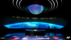 Staff members explain to visitors at the Museum of the Future, in Dubai, United Arab Emirates, Wednesday, Feb. 23, 2022. (AP Photo/Kamran Jebreili)