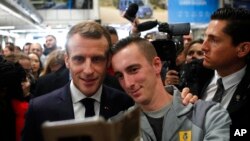FILE - French President Emmanuel Macron poses for a photo with a worker at the French carmaker Renault factory of Maubeuge, northern France, Nov.8, 2018.