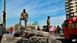 Pripadnici bezbednosnih snaga stražare na barijeri koja blokira mesto održavanja demonstracija tokom antivladinih protesta u Bagdadu, Irak, 15. februara 2020. (AP Photo/Hadi Mizban)