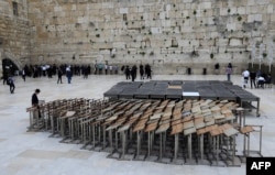 Seorang Yahudi ultra-Ortodoks berdiri melewati mimbar doa di Tembok Barat yang hampir kosong, situs paling suci Yudaisme. (Foto: AFP)