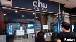 People look inside Chu Chocolate Bar & Cafe days after it permanently closed due to business lost as a result of coronavirus restrictions, in Bangkok, Thailand, June 1, 2021.