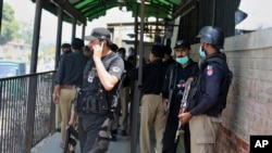 Polisi berkumpul di pintu masuk pengadilan distrik di Peshawar, Pakistan, menyusul tewasnya Tahir Shamim Ahmad, yang ditembak oleh pengunjung saat berada di dalam ruang sidang atas tuduhan menghina Islam, Rabu, 29 Juli 2020.