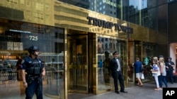 People pass police security and a building doorman as the enter Trump Tower in New York Thursday, Aug. 14, 2017. (AP Photo/Craig Ruttle)