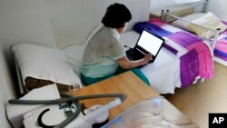 FILE - 17-year-old Yazidi girl, Yasmin, sits in a room of her home in Germany after escaping the clutches of Islamic State. She was so traumatized by her captivity that she poured gasoline on herself and set it alight, hoping to render herself no longer desirable, July 28, 2016.