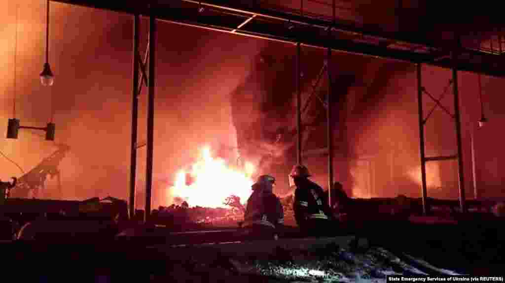 Fire fighters extinguish fire in an oil depot that Ukraine&#39;s State Emergency Services say was caused by Russian strikes in Zhytomyr region, March 7, 2022 in this still image obtained from a handout video.