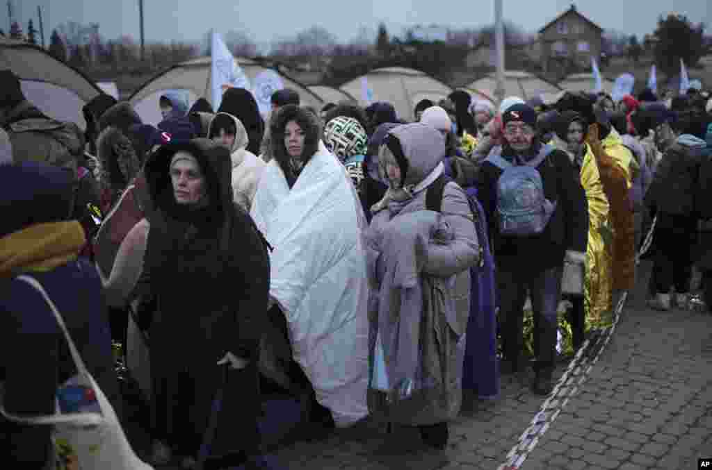 Refugees wait for transportation after fleeing from Ukraine and arriving at the border crossing in Medyka, Poland, March 7, 2022.