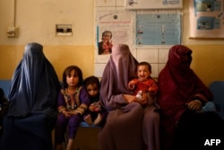 FILE - Women wait with their children at a maternity clinic in a rural area of Dand district in Kandahar province, Oct. 1, 2020.