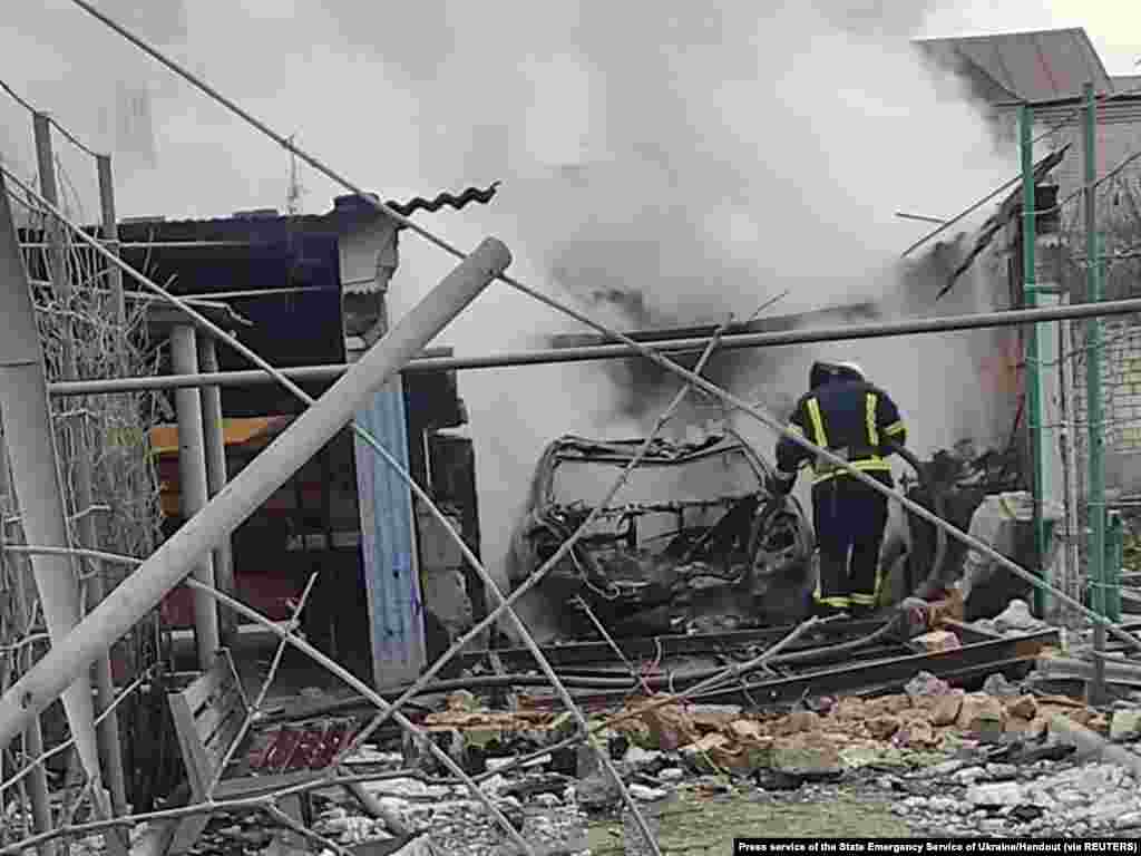 A rescuer is seen in a residential building damaged by Russian shelling in Mykolaiv in this handout picture released on March 8, 2022.
