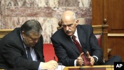 Greece's Prime Minister George Papandreou (r) talks with Finance Minister Evangelos Venizelos during a parliament session in Athens June 30, 2011.