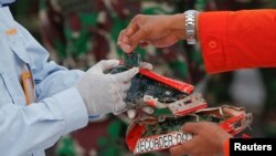 Direktur SAR Rasman MS memberikan sampul Cockpit Voice Recoder (CVR) dan Flight Data Recorder (FDR) penerbangan Sriwijaya Air SJ 182 yang jatuh di Pulau Jawa kepada petugas KNKT di pelabuhan Tanjung Priok, Jakarta, 17 Januari 2021. (REUTERS/Willy Kurniawan)