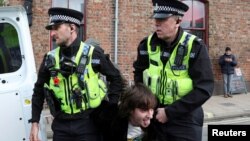 Police officers carry a man who threw an egg at King Charles into a police van during the king's visit to Micklegate bar in York, Britain Nov. 9, 2022.