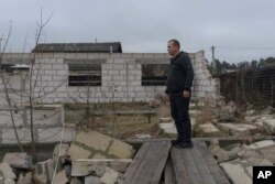 Vadym Zherdetsky stands amid the wreckage of his house destroyed by fighting in the village of Moshun, outside Kyiv, Ukraine, Friday, Nov. 4, 2022.
