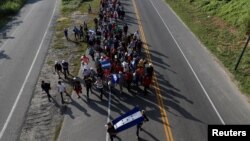 Central American migrants, part of a caravan trying to reach the U.S., walk along the road as they continue their journey, in Ciudad Hidalgo, Mexico, Oct. 26, 2018. 