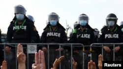 រូបឯកសារ៖ ក្រុមបាតុករ​ដែល​ប្រឈមមុខ​នឹង​ប៉ូលិស បាន​លើក​ម្រាមដៃ​បី​ជា​សញ្ញា​នៃ​ការប្រឆាំង​ក្នុង​អំឡុងពេល​បាតុកម្ម​ប្រឆាំងនឹង​រដ្ឋាភិបាល​នៅ​ខាងក្រៅ​វិមាន​រដ្ឋាភិបាល​ក្នុង​ទីក្រុង​បាងកក ប្រទេសថៃ កាលពី​ថ្ងៃទី៣០ ខែមីនា ឆ្នាំ២០២១។