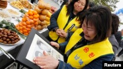 지난 2011년 한국 비무장 지대 인근 임진각에서 납북자 추모 행사가 열린 가운데, 납북 희생자 가족들이 사진을 들고 울고 있다. (자료사진)