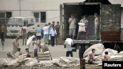 지난 2010년 중국 단둥 시와 마주보는 북한 신의주 압록강 인근에서 주민들이 중국산 밀가루를 트럭에 싣고 있다. (자료사진)