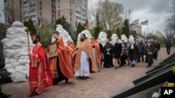 Sejumlah pendeta Kristen Ortodoks menggelar upacara pemberkatan untuk menghormati para pemadam kebakaran di Chernobyl dalam rangka peringatan 36 tahun insiden nuklir di lokasi tersebut. Acara itu digelar di Kyiv, Ukraina, pada 26 April 2022. (Foto: AP/Efrem Lukatsky)