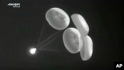 In this image from infrared video provided by SpaceX, the Dragon space capsule uses parachutes as it descends to the Atlantic Ocean off the Florida coast on Monday, April 25, 2022. (SpaceX via AP)