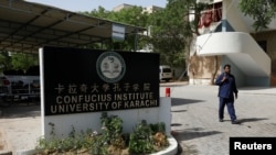 FILE - A security guard patrols after a blast at the entrance of the Confucius Institute at the University of Karachi, in Pakistan, April 26, 2022.
