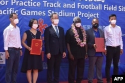 所罗门群岛总理索加瓦雷（右三）与中国驻所罗门群岛大使李明（左三）与其他官员在霍尼亚拉中国援建的体育馆项目开工仪式上合影。（2022年4月22日）